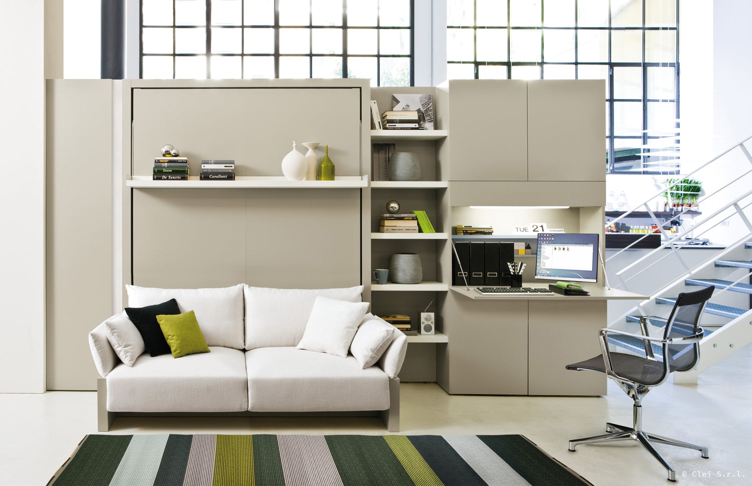 Canapé convertible avec bureau intégré, étagères et décoration moderne, dans un espace lumineux signé Clei Nuovoliola 10