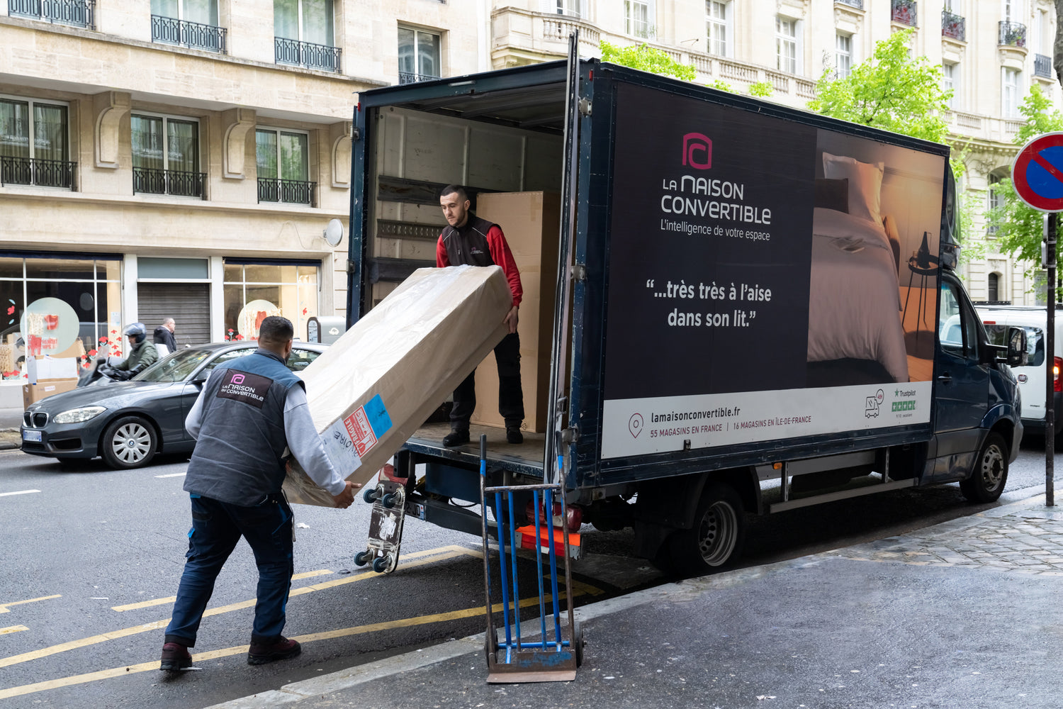 Camion de livraison "La Maison Convertible" déchargeant un colis à l'adresse 85 avenue Victor Hugo, Paris