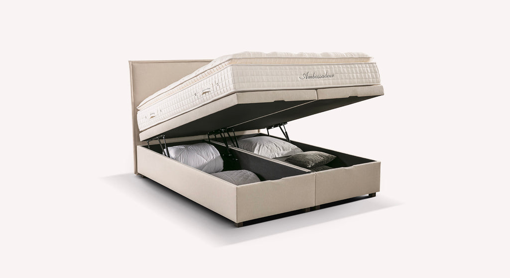 Lit coffre beige "Ibiza" avec matelas relevable, offrant un espace de rangement pour oreillers et couvertures