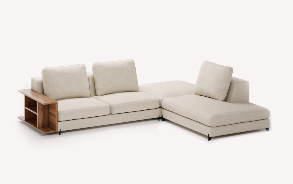 Canapé d'angle en tissu ivoire avec pouf intégré, modèle Nelly, doté d'une étagère en bois sur le côté