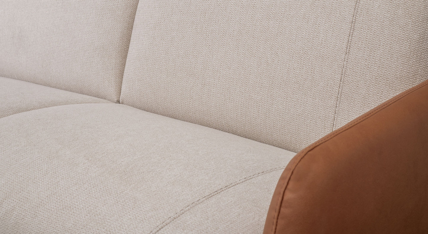 Zoom sur le tissu ivoire d'un canapé convertible, modèle Echo Aragon, avec accoudoir en cuir marron