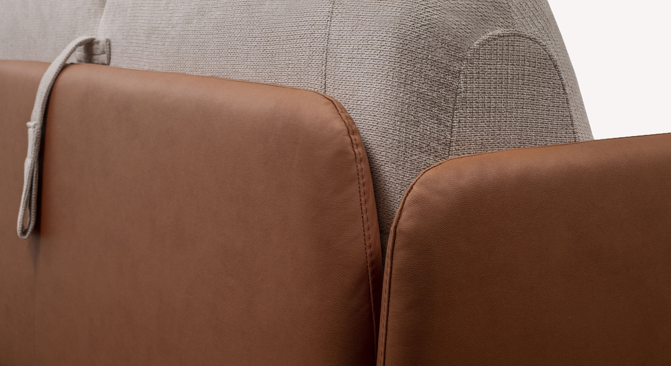 Détail rapproché du canapé convertible ECHO Aragon Ivoire / Monet/4518-Cognac montrant l’association de tissu ivoire et simili cuir cognac pour un style élégant et confortable.