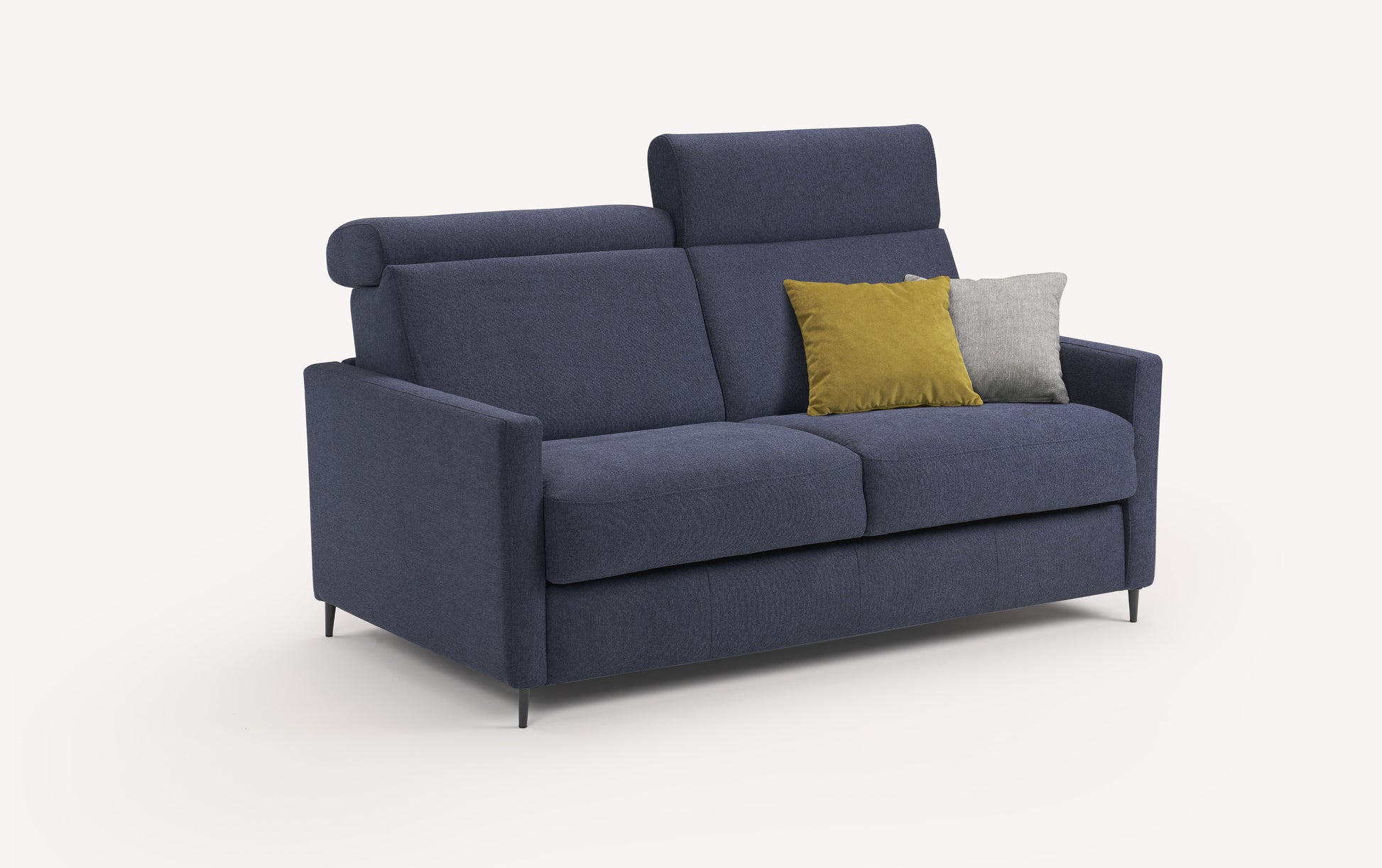 Canapé convertible Amy en tissu bleu profond avec coussins jaune et gris, vu de trois quarts