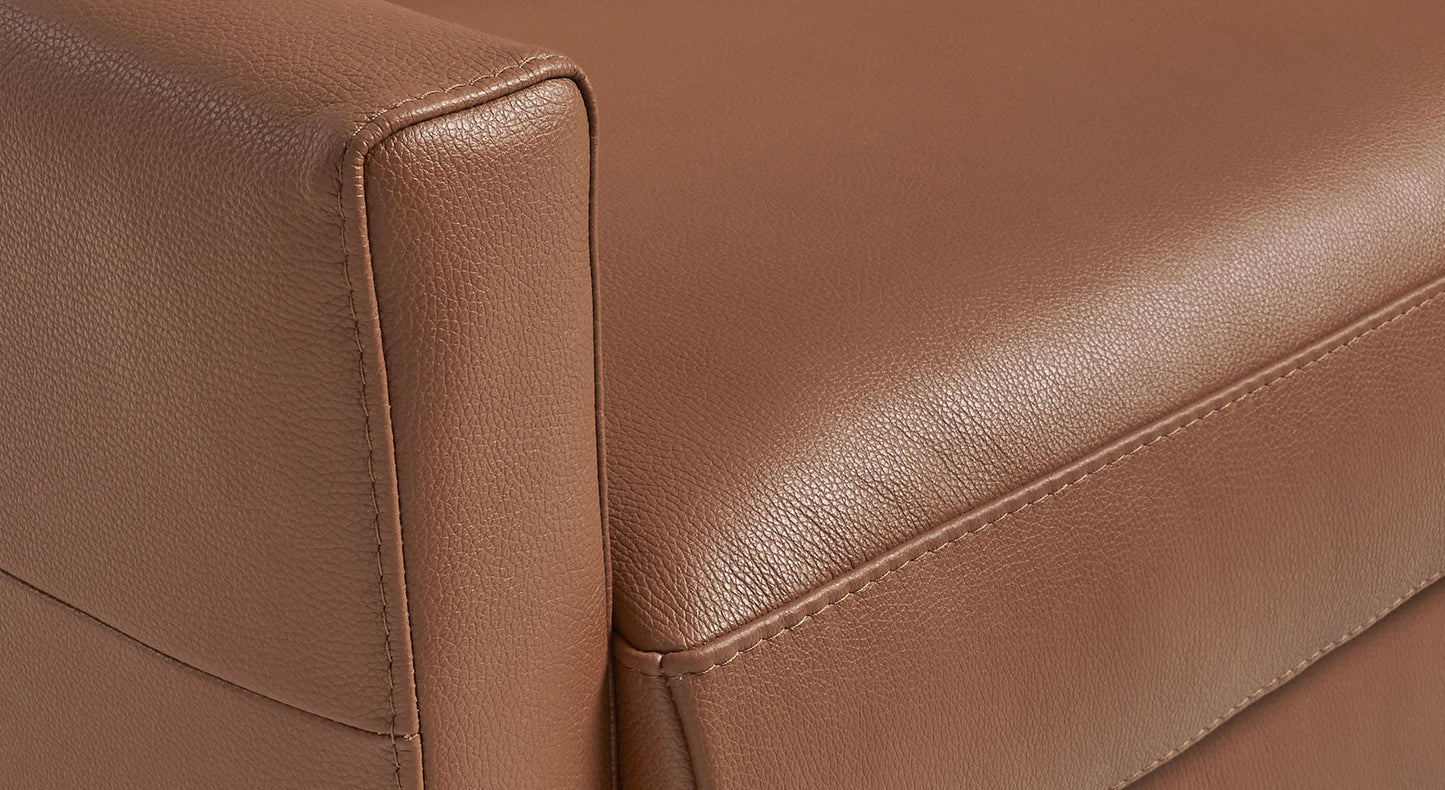 Détail en gros plan du revêtement en cuir marron du canapé BOBBY Cuir Lux Cognac mettant en valeur la texture fine et la qualité du matériau.