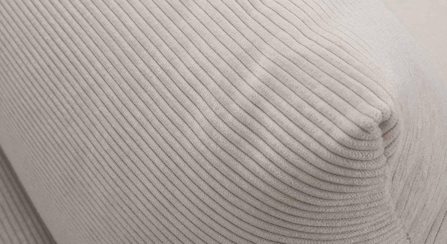 Détail en gros plan du tissu côtelé beige naturel utilisé pour le canapé convertible GAIA Teatro Sand, illustrant la texture douce et élégante du revêtement.