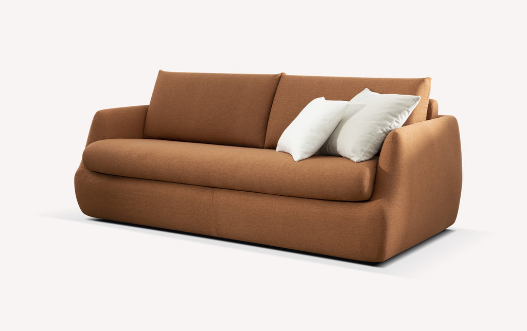 Canapé convertible en tissu couleur cuivre, modèle Luz, avec deux coussins blancs
