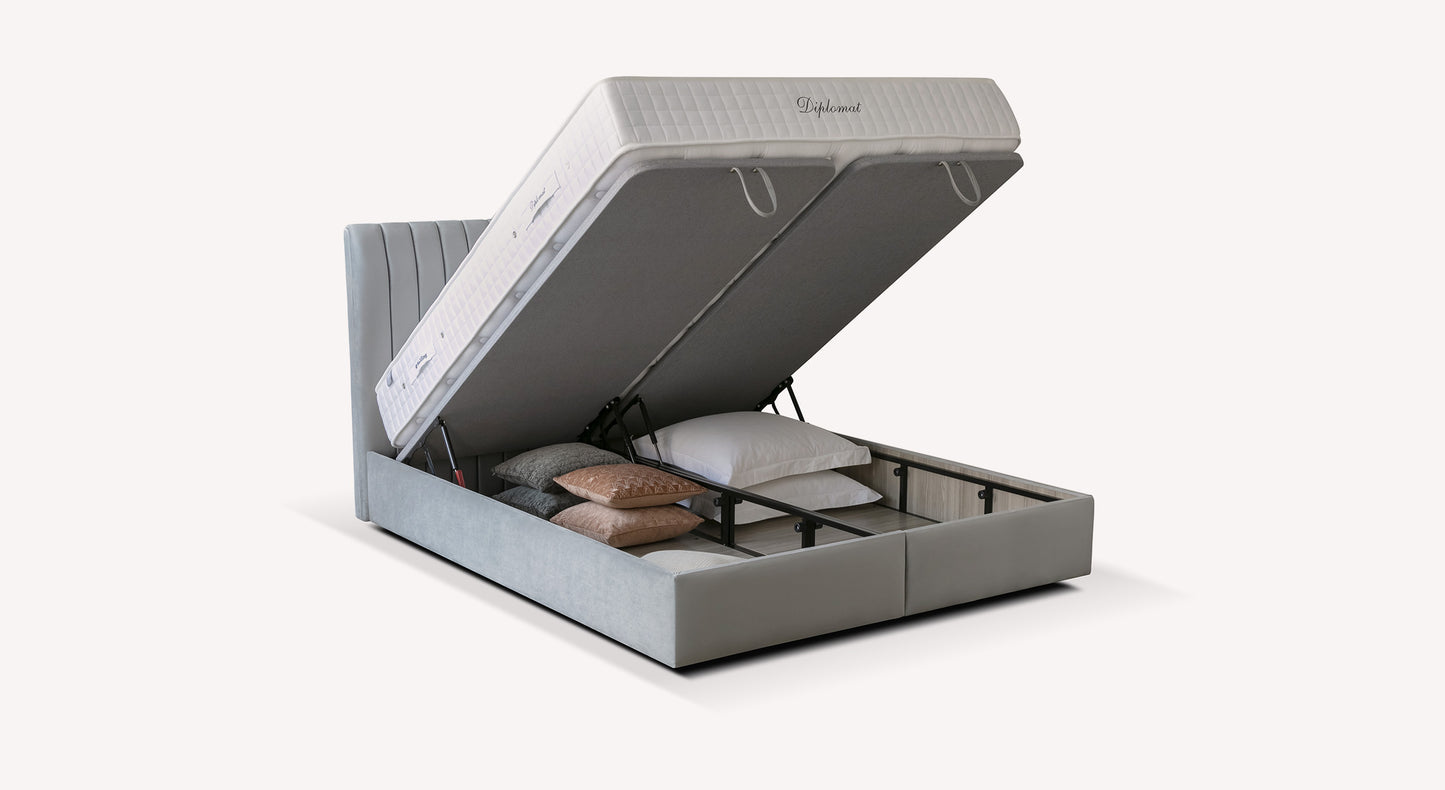 Lit coffre gris avec matelas relevable, offrant un espace de rangement pour oreillers et coussins. Modèle "Diplomat"